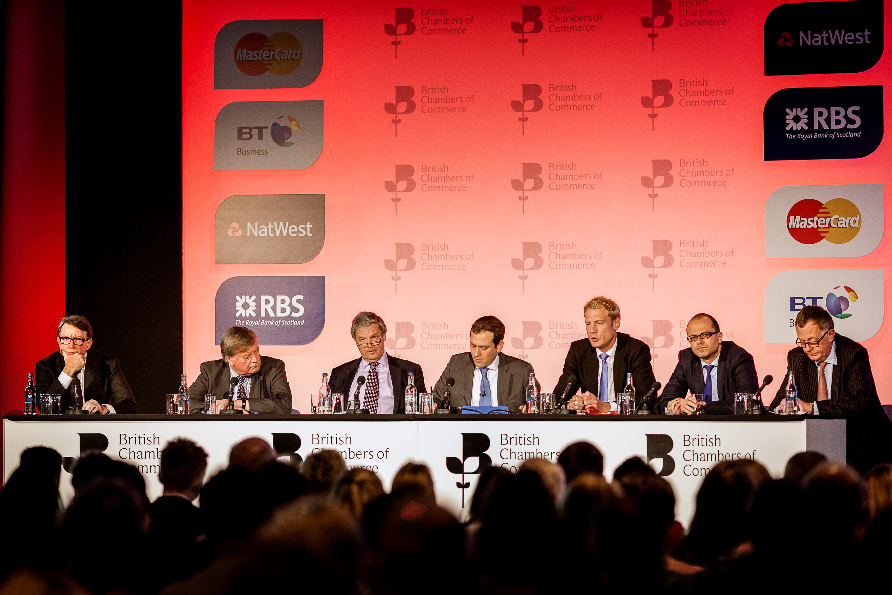 Men wearing suits attending as British Chamber of Commerce Conference panel