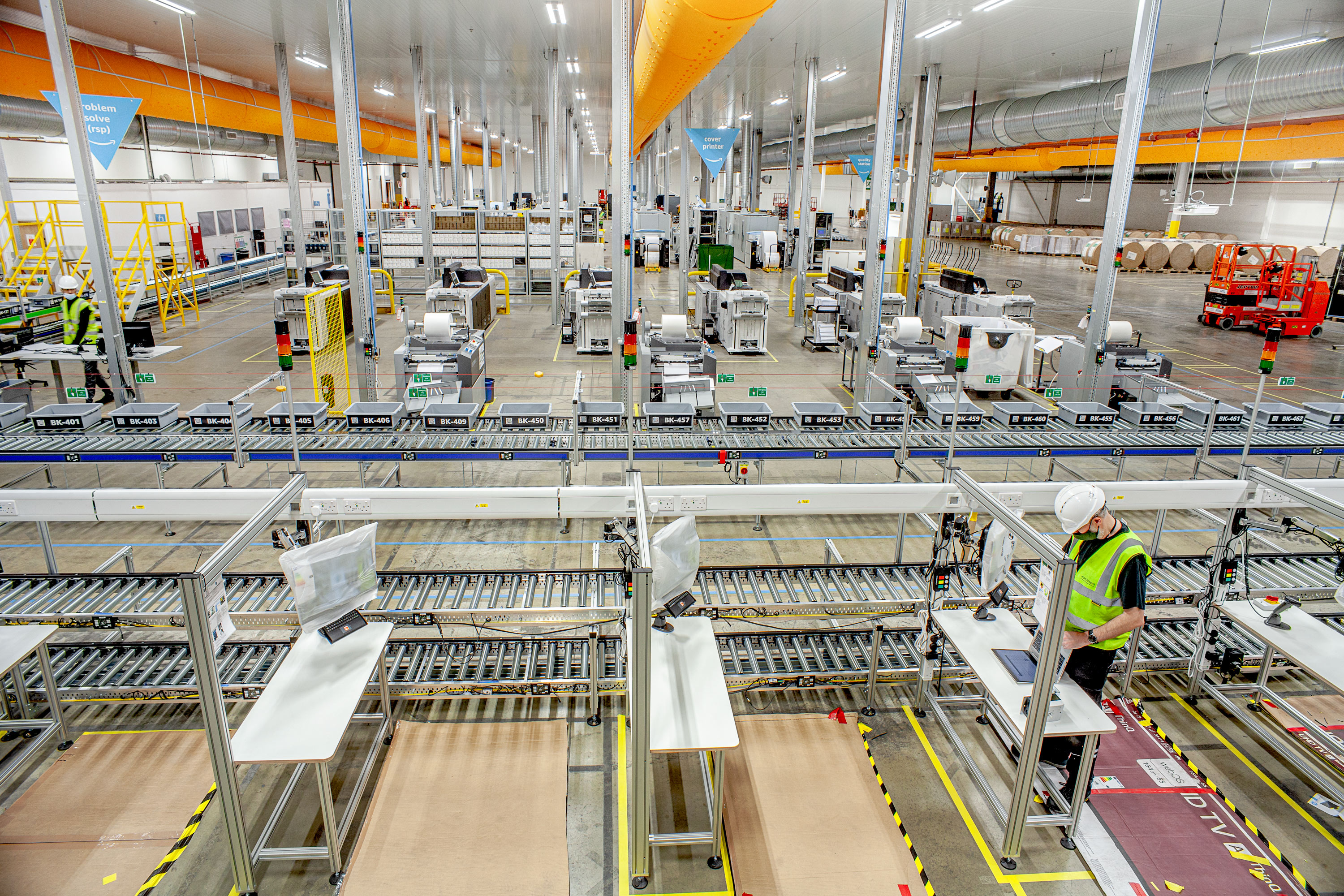 Commercial packing line inside industrial unit with men in hi-vis jackets