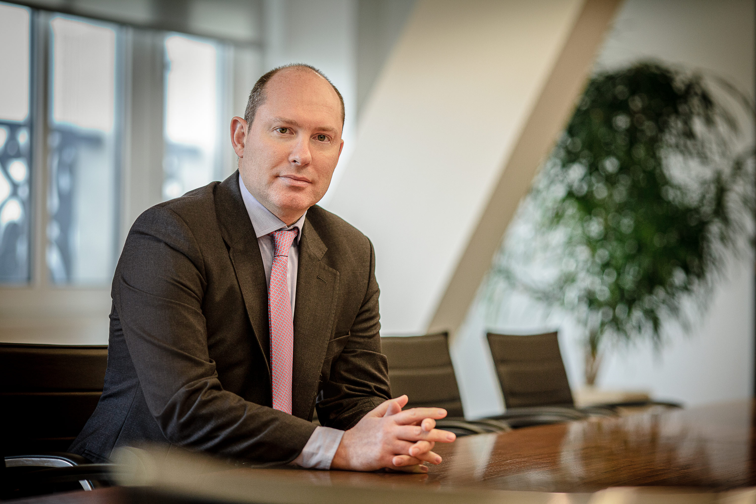 Business portrait of male employee sitting at meeting table