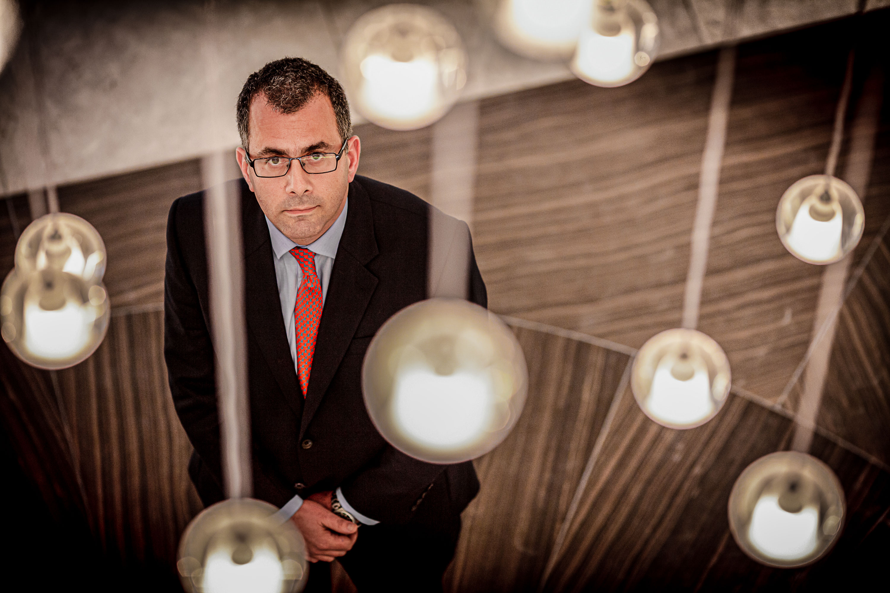 Business headshot of a man shot from a high camera angle by the photographer, framed by a soft foreground