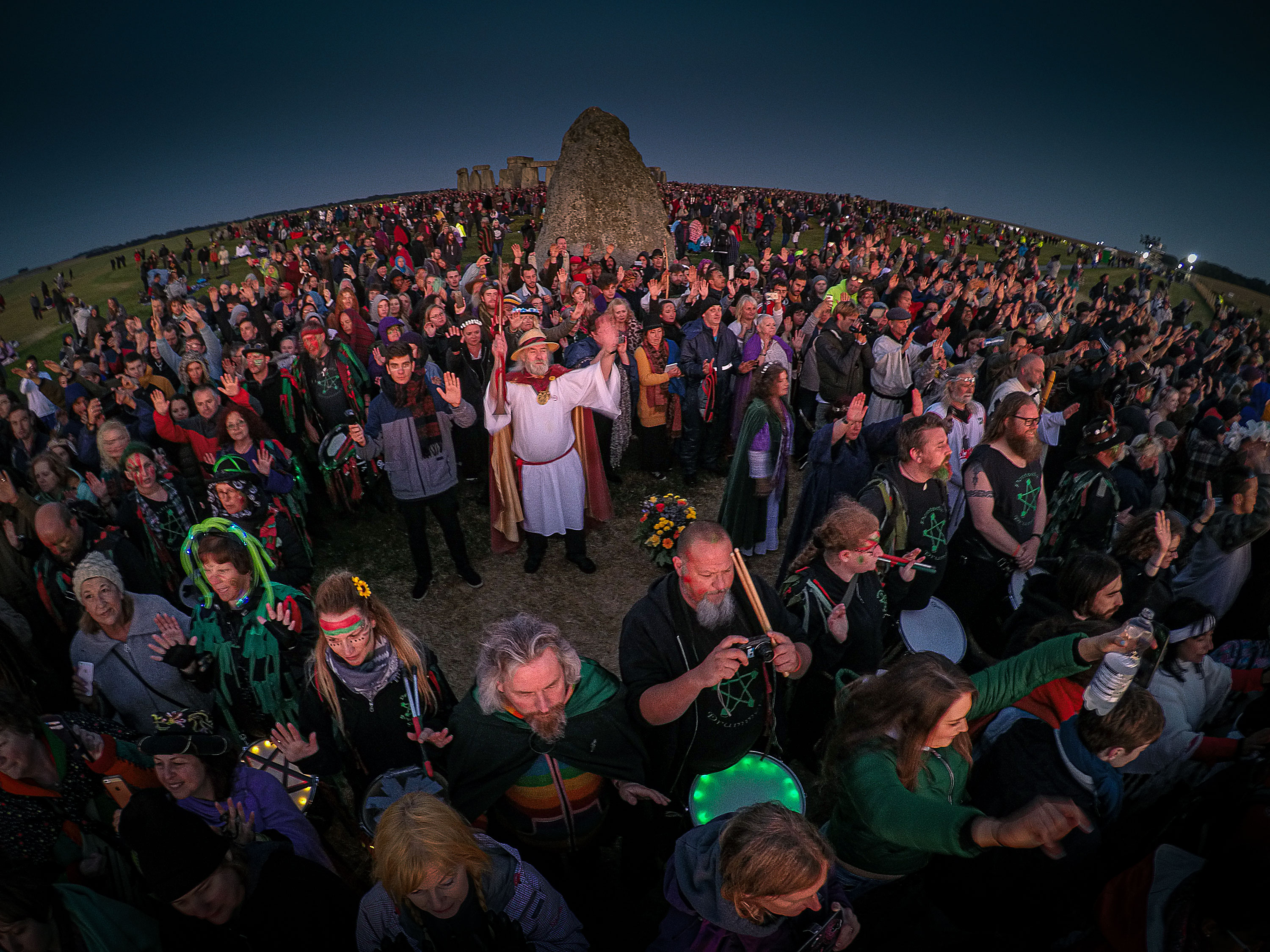Wide-angle photography of the crowd at Stonehenge celebrating the summer solstice