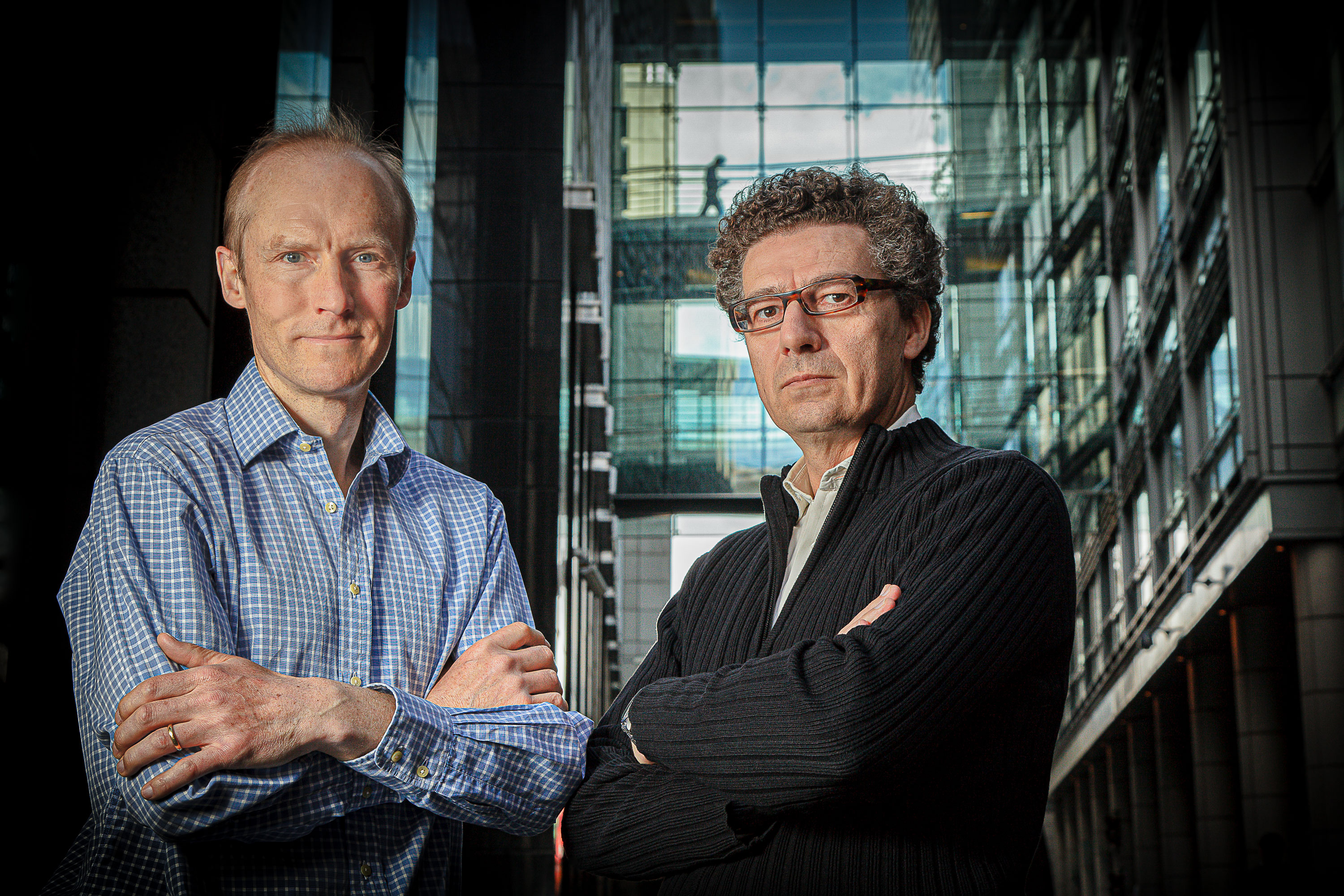Team photography of two men with folded arms in a high rise office setting