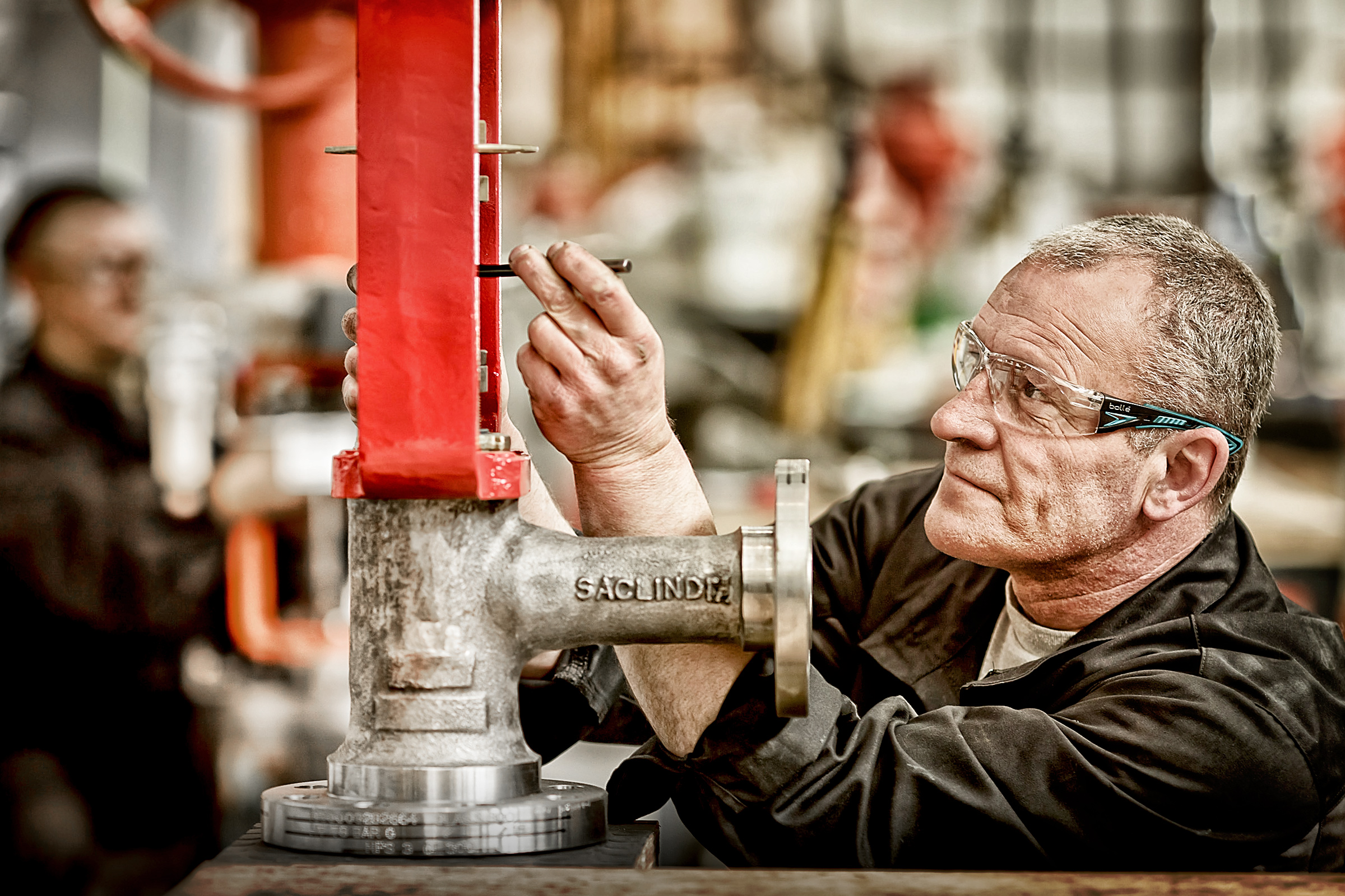 Industrial manufacturing photo showing a man working on a pump